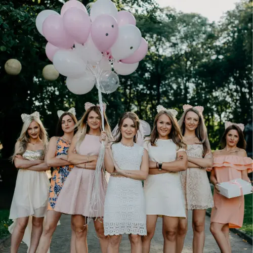 Group of women in festive attire holding balloons at a bridal shower celebration, showcasing a joyful atmosphere for event catering in Pittsburgh.
