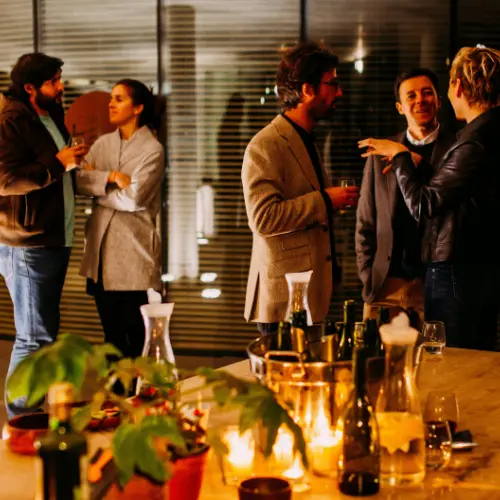 Group of people enjoying a corporate event with drinks and food, showcasing a social atmosphere for catering services in Pittsburgh.